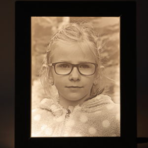Portrét dievčaťa technikou litofánie. Obrázok je podsvietený led pásikom.
